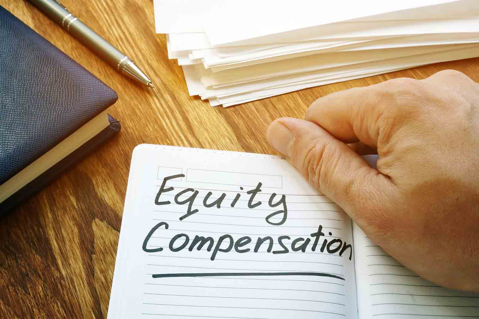 Holding a notebook reading "Equity Compensation"