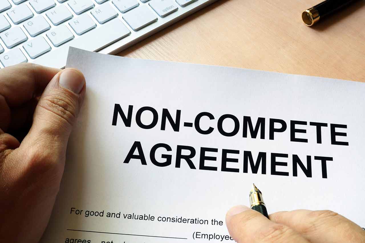 A close up of a document titled non-compete agreement being held by an Orlando attorney
