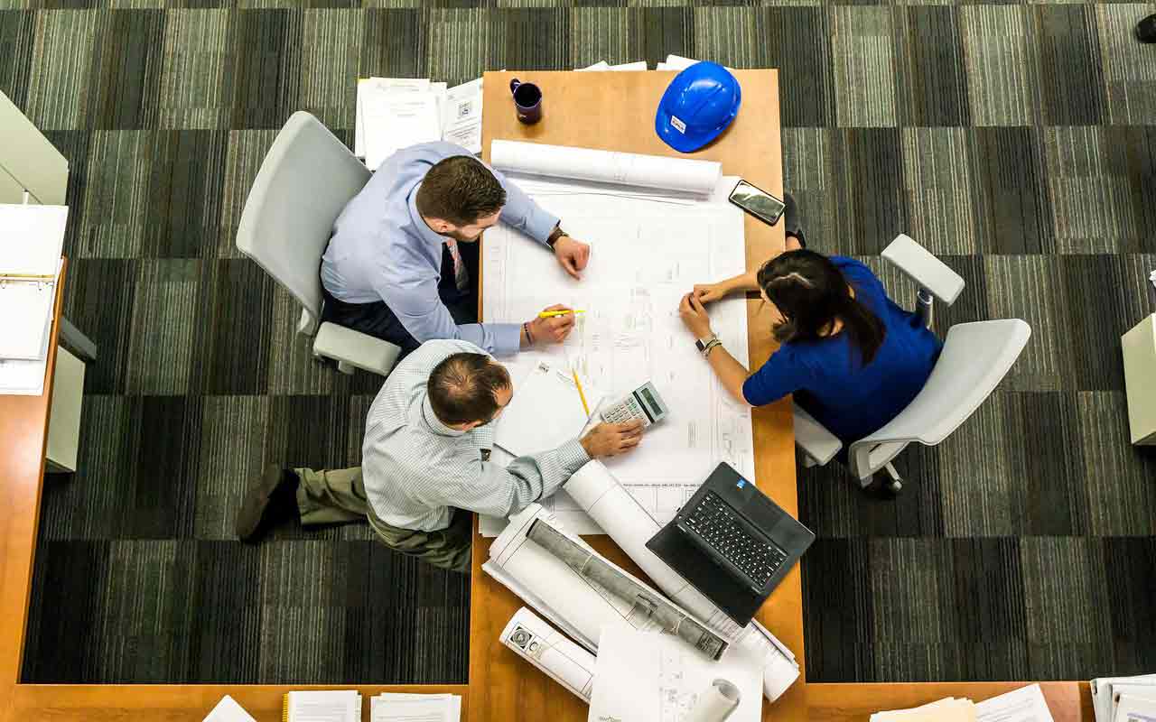 business partners looking tense as they sit at a table trying to work out a disagreement about their business