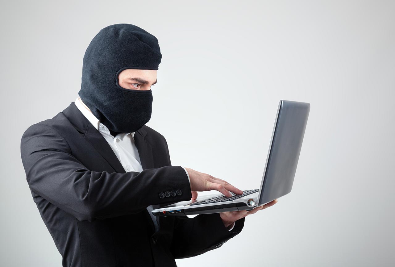 Picture of an employee in a business suit accessing a stolen customer list on his personal laptop.