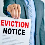 Landlord holding a commercial eviction notice to commercial tenant.