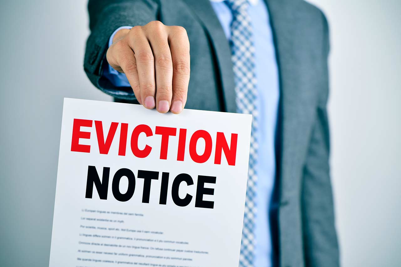 Landlord holding a commercial eviction notice to commercial tenant.