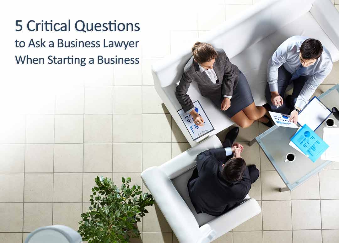 Entrepreneurs sitting at a table meeting with a business lawyer with text overlay that reads 5 critical questions to ask a business lawyer when starting a business